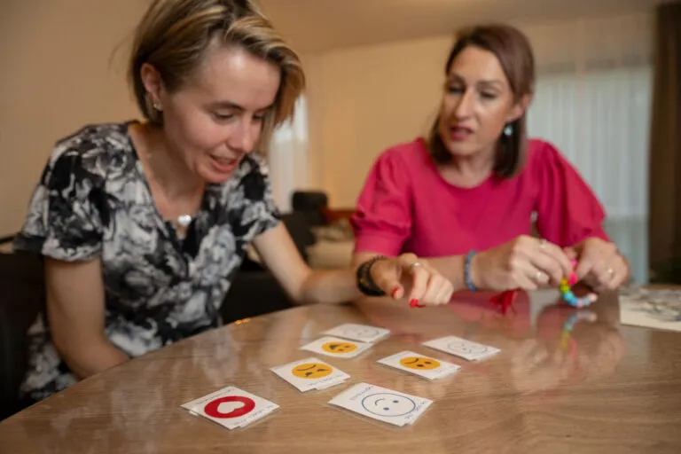 Doelgroep autisme, Amarant, cliënt speelt spel aan tafel met zorgprofessional