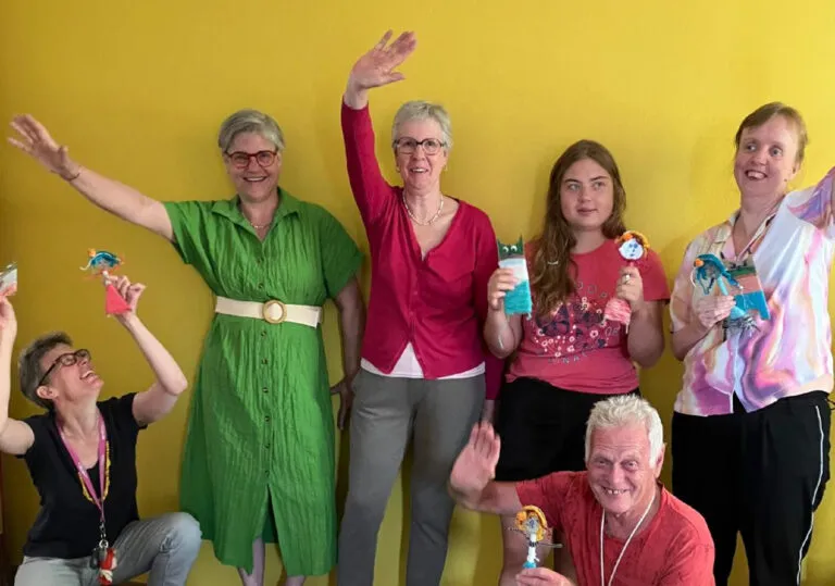 Agnes en marlies, vrijwilligers koken en creatief, zwaaien met groep cliënten naar de camera
